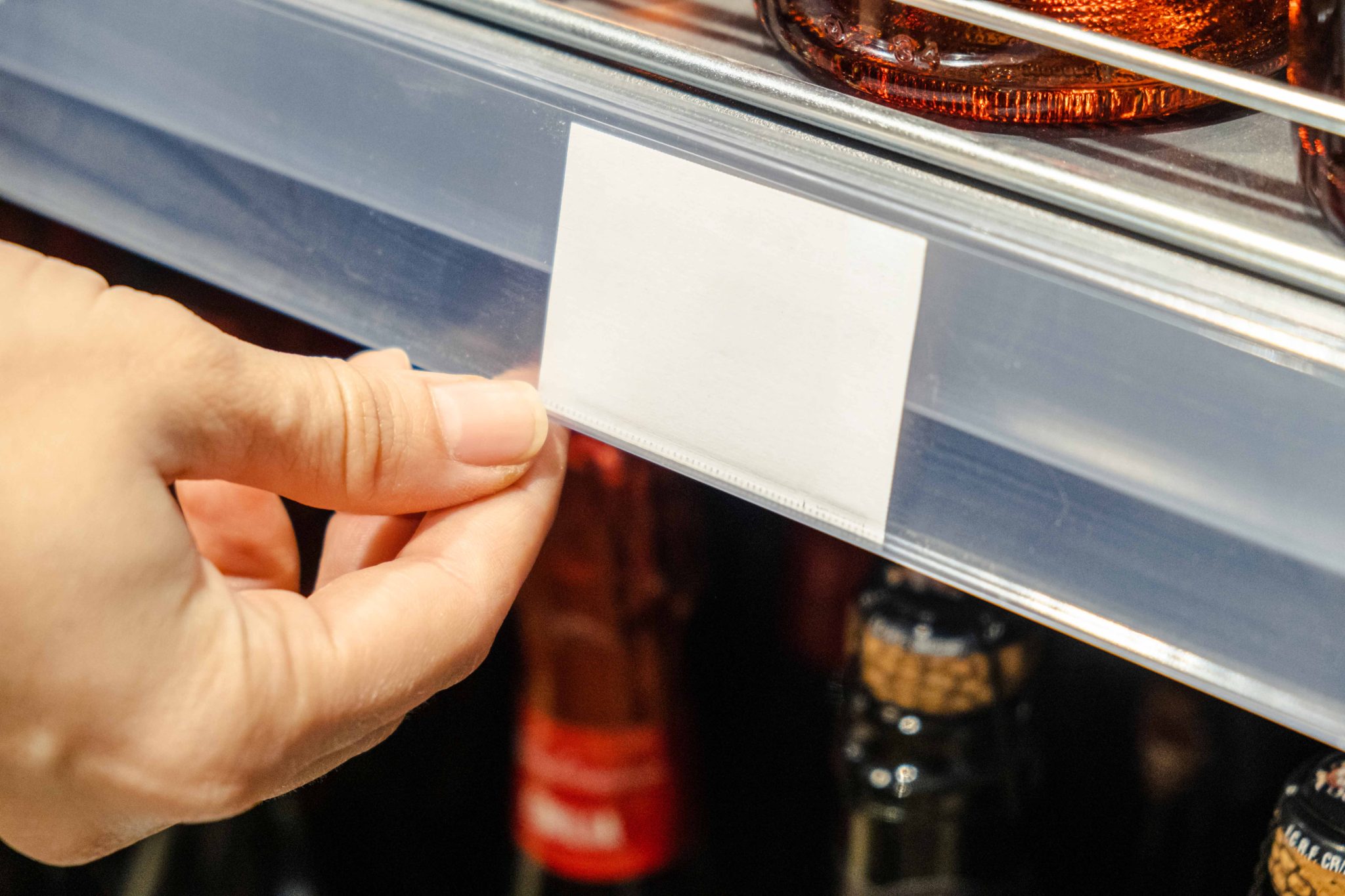 Woman's hand indicates price label in store
